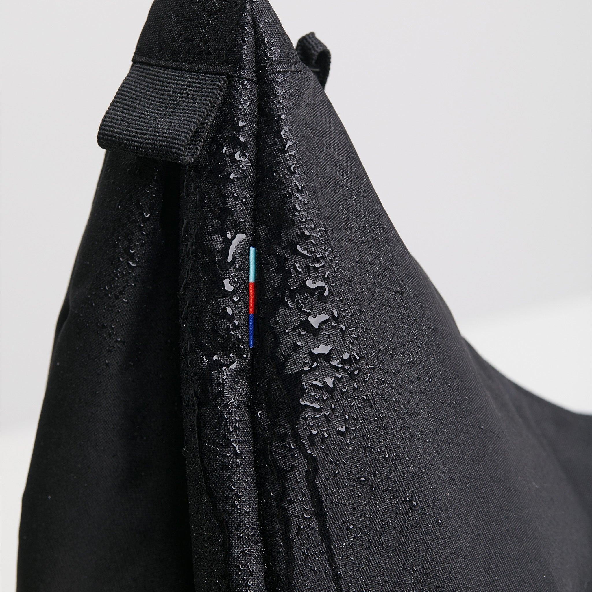 MOON BAG LARGE Tasche in black (Schwarz) mit Wassertropfen und farbigem Detail.