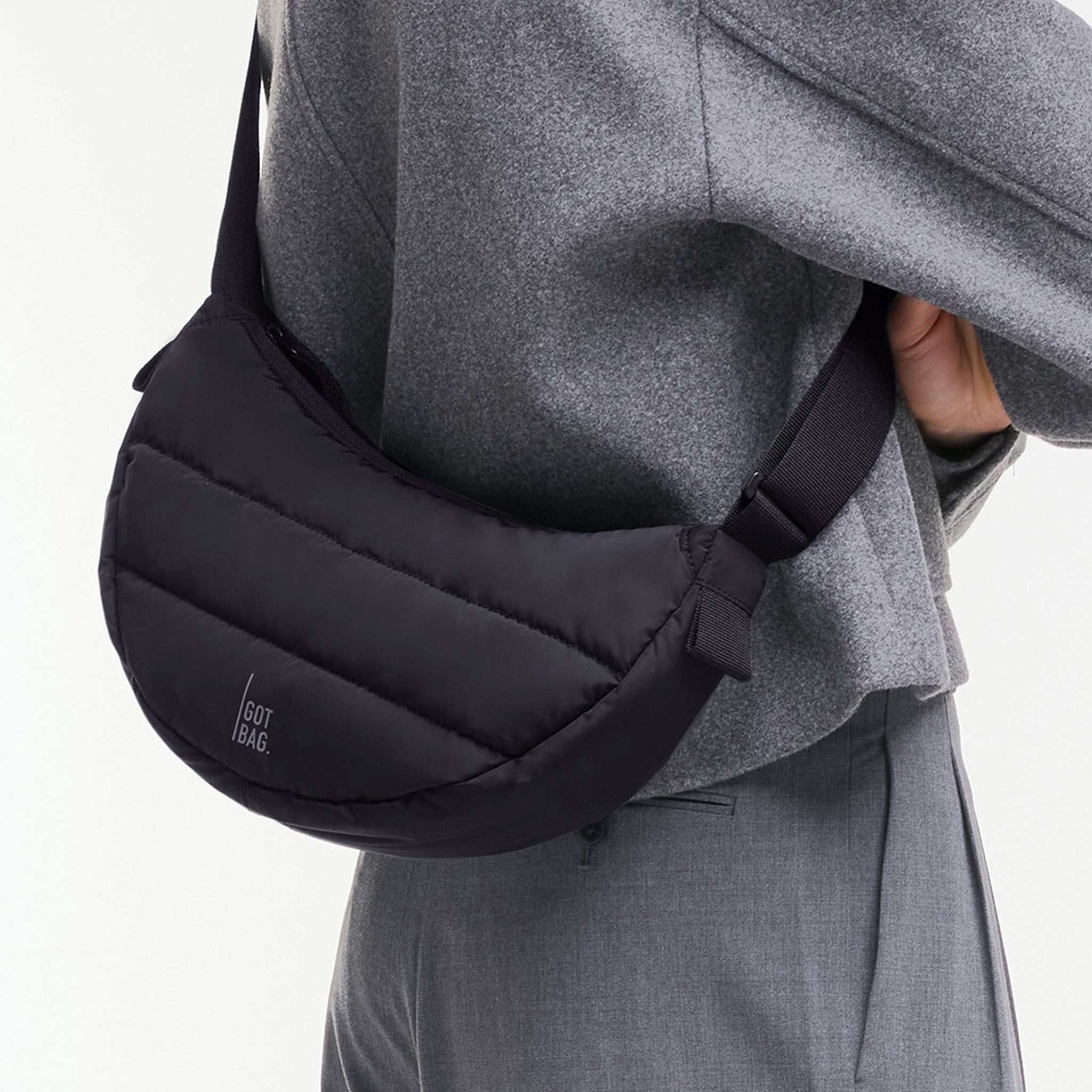 PUFFER MOON BAG SMALL Tasche in black (Schwarz) von einem Mann crossbody getragen.