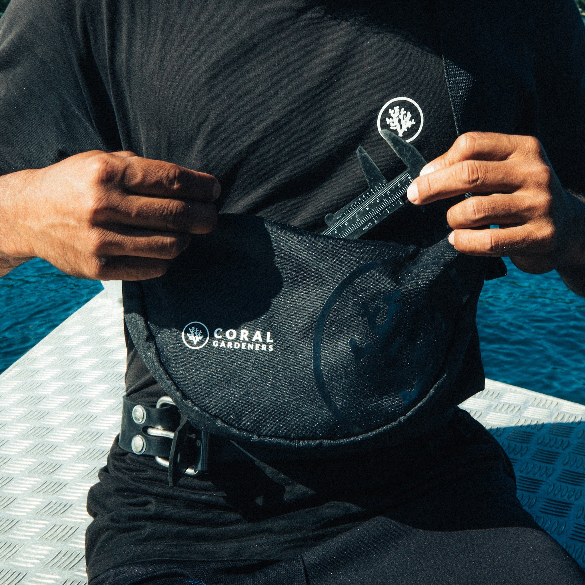 MOON BAG SMALL Tasche in black (Schwarz) von einem Mann um die Hüfte getragen.