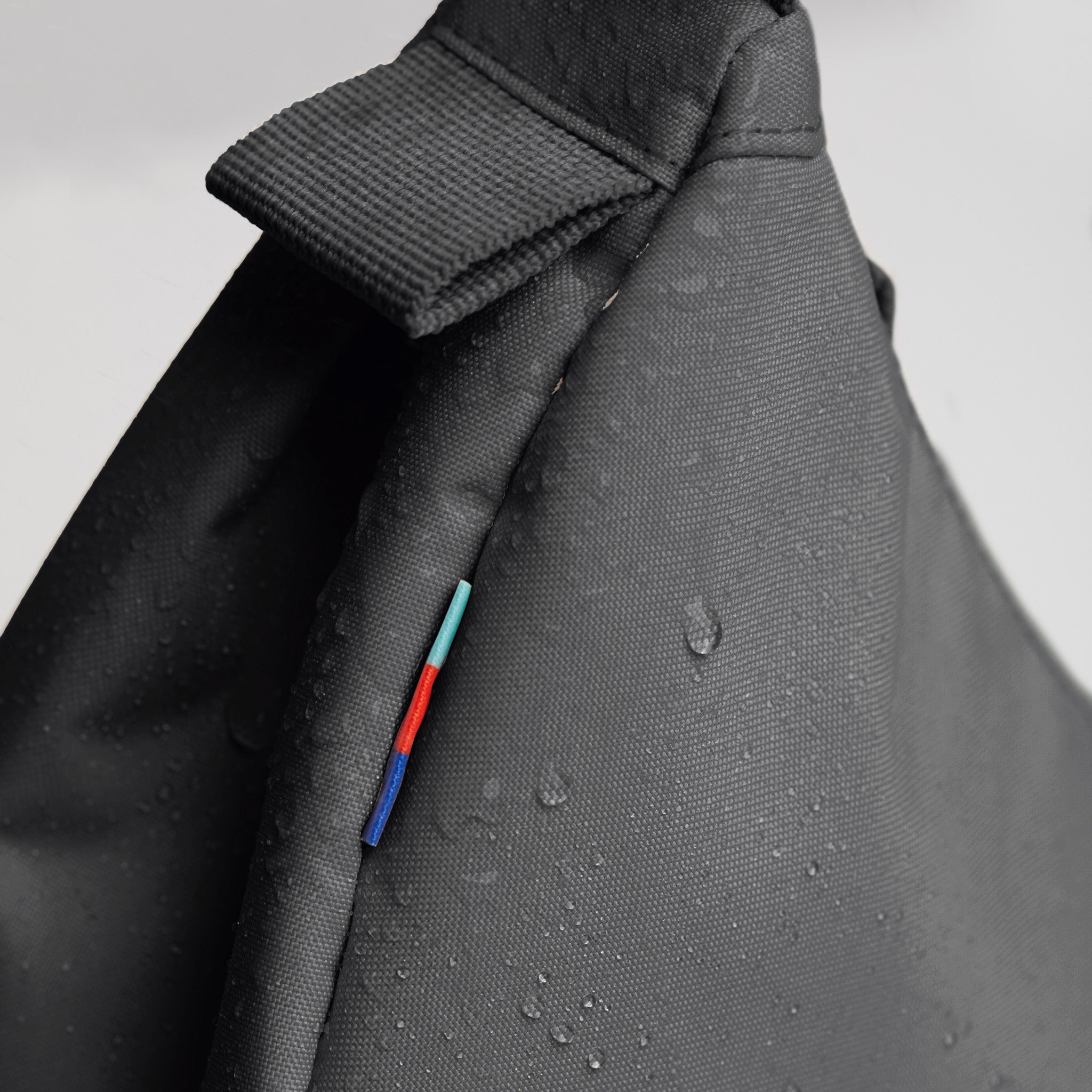 MOON BAG SMALL Tasche in shark (Dunkelgrau) mit Wassertropfen als Detailaufnahme.