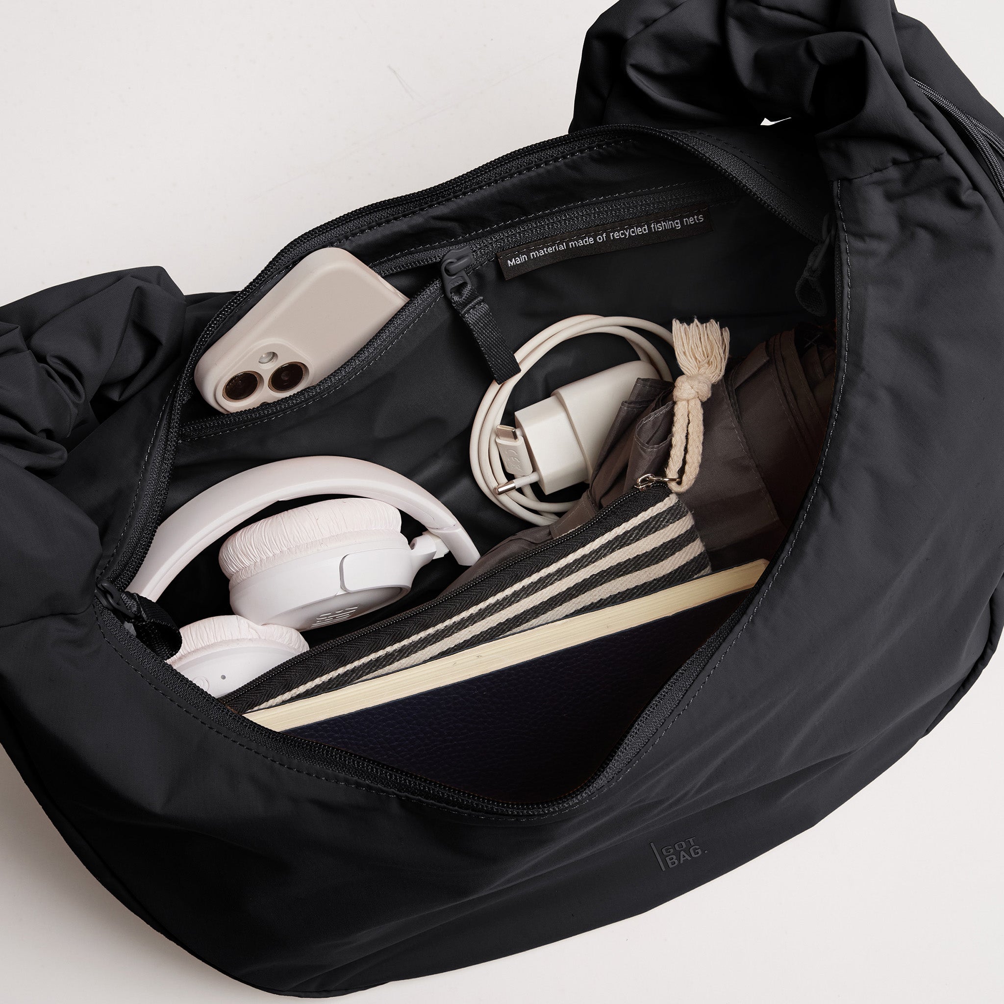 MOON BAG RUFFLE Tasche in black (Schwarz) mit Blick ins gefüllte Innere.