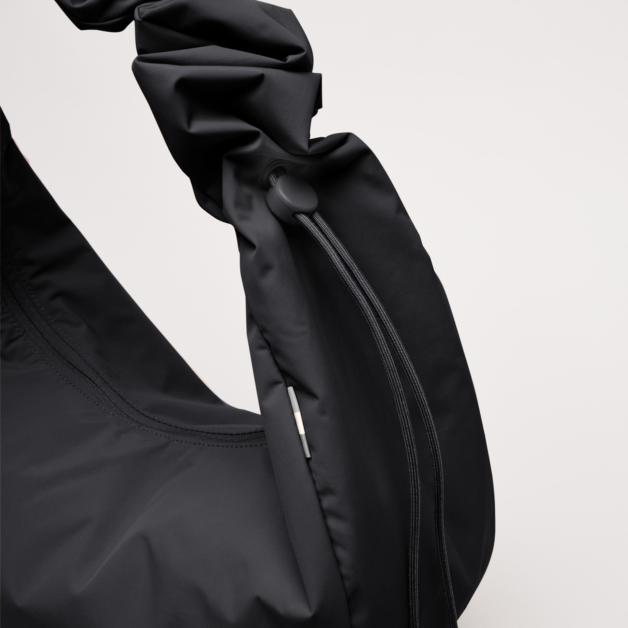MOON BAG RUFFLE Tasche in black (Schwarz) mit Kordelzug und Raffung.