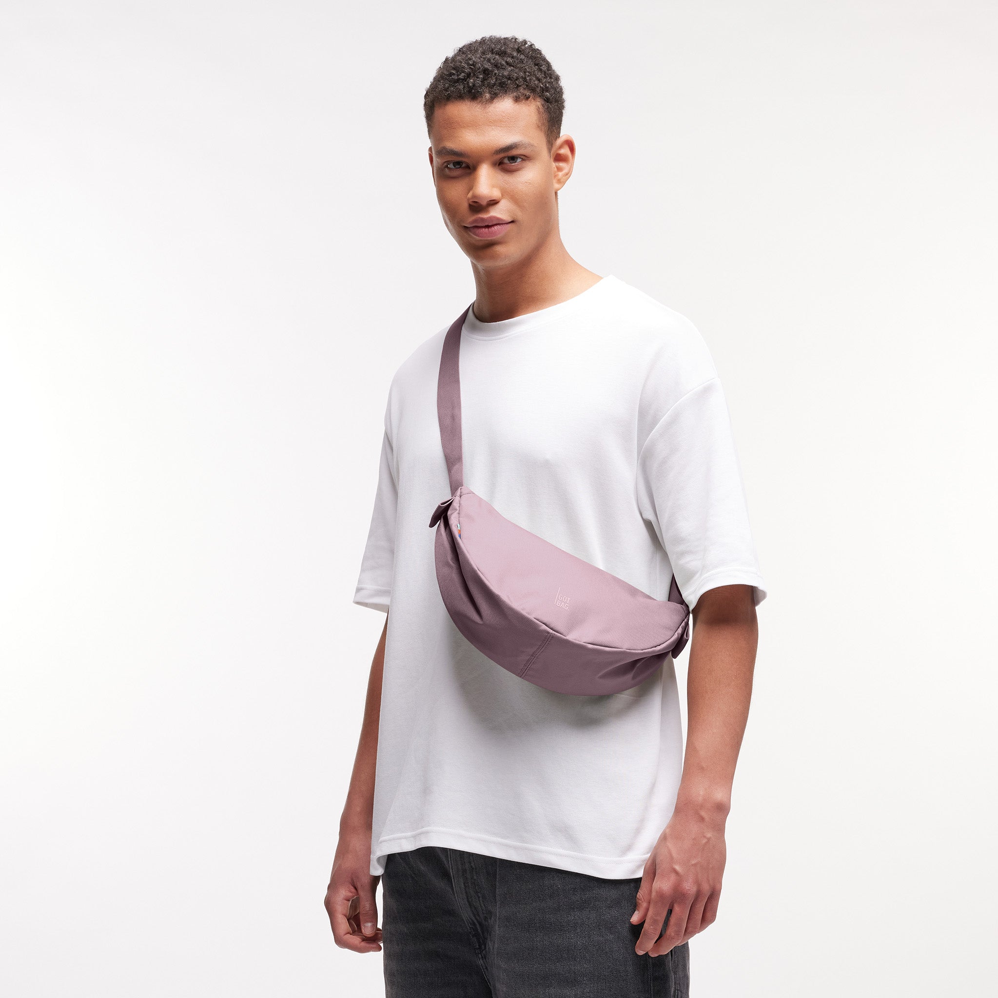 MOON BAG SMALL Monochrome Edition Tasche in calamary (Altrosa) von einem Mann crossbody getragen.