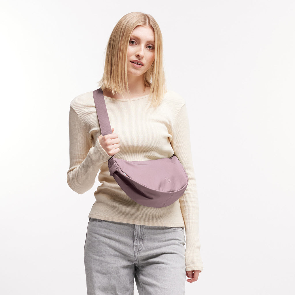 MOON BAG SMALL Tasche in calamary (Altrosa) von einer Frau crossbody getragen.