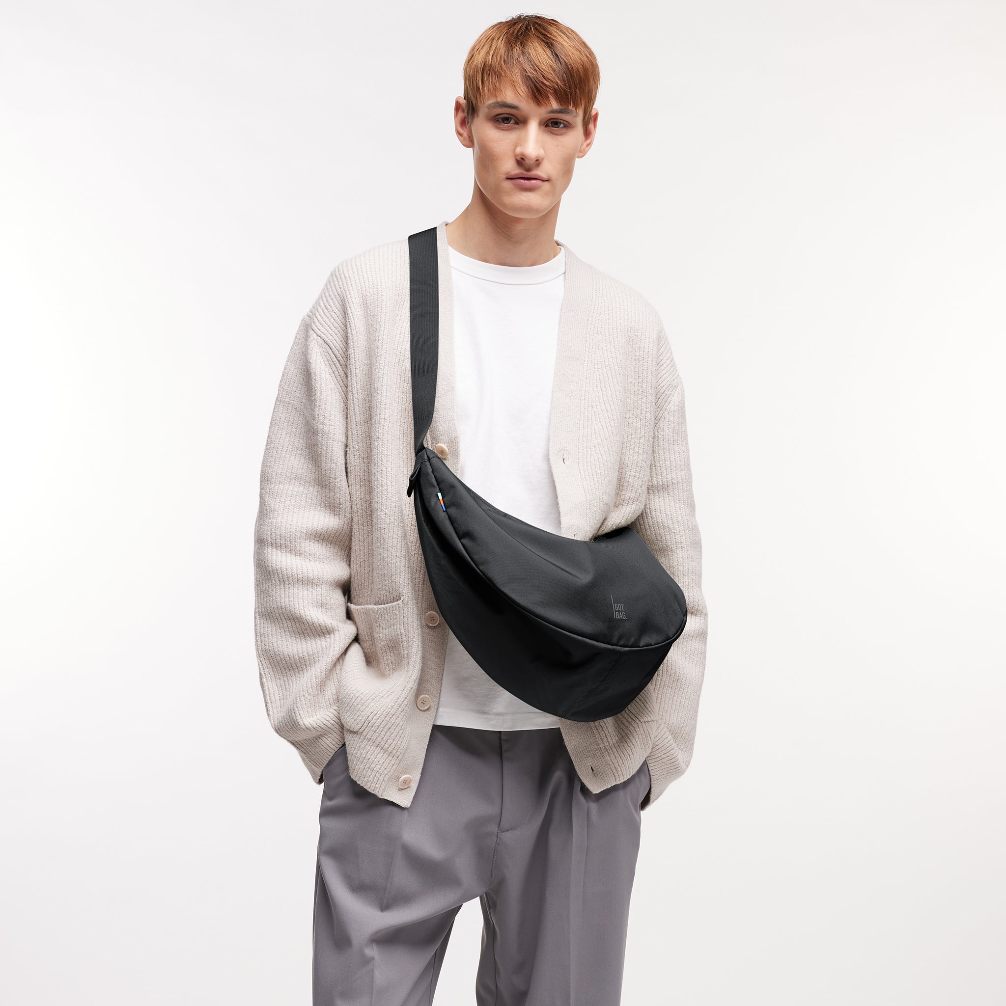 MOON BAG LARGE Tasche in black (Schwarz) von einem Mann crossbody getragen.