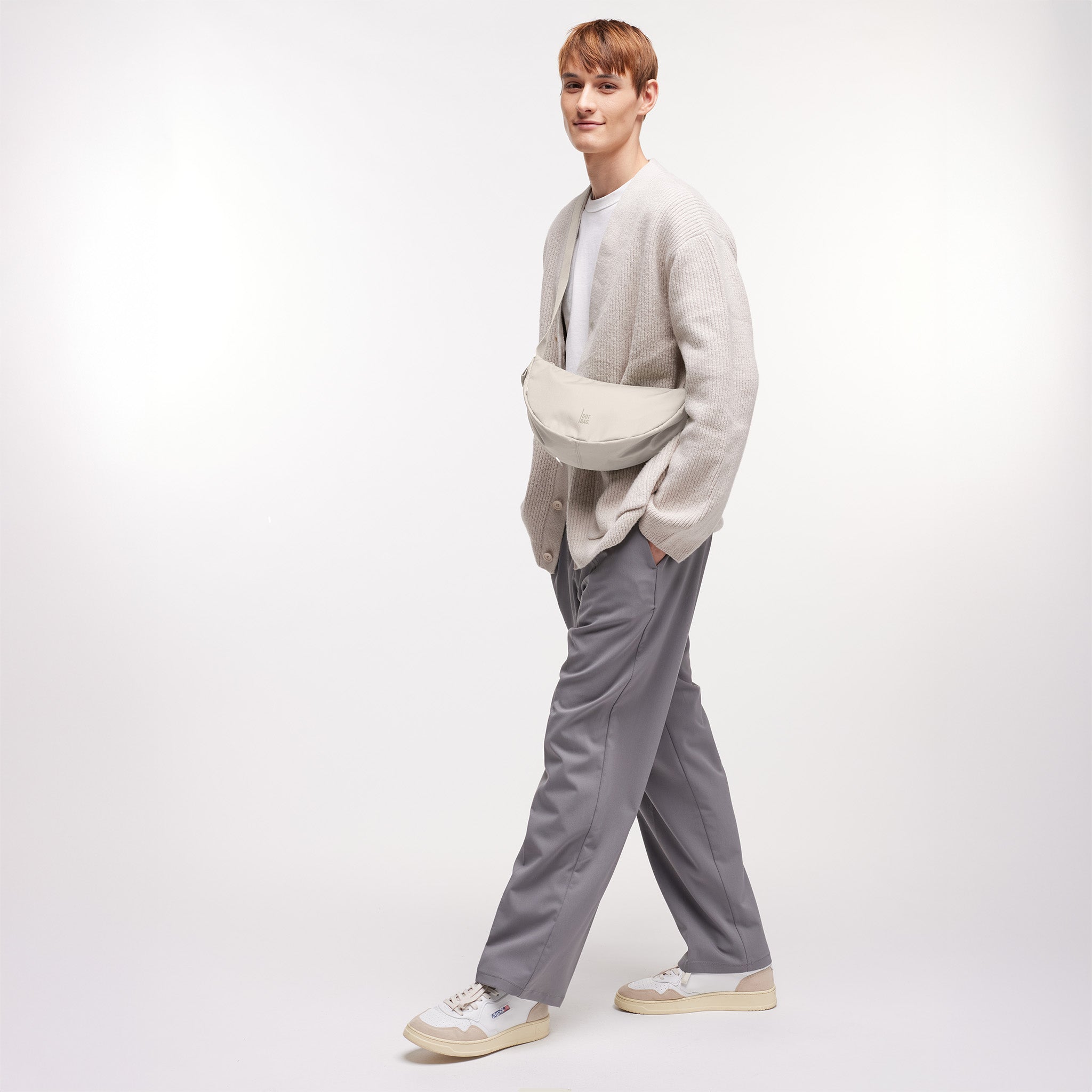 MOON BAG SMALL Tasche in soft shell (warmes Cremeweiß) von einem Mann crossbody getragen.