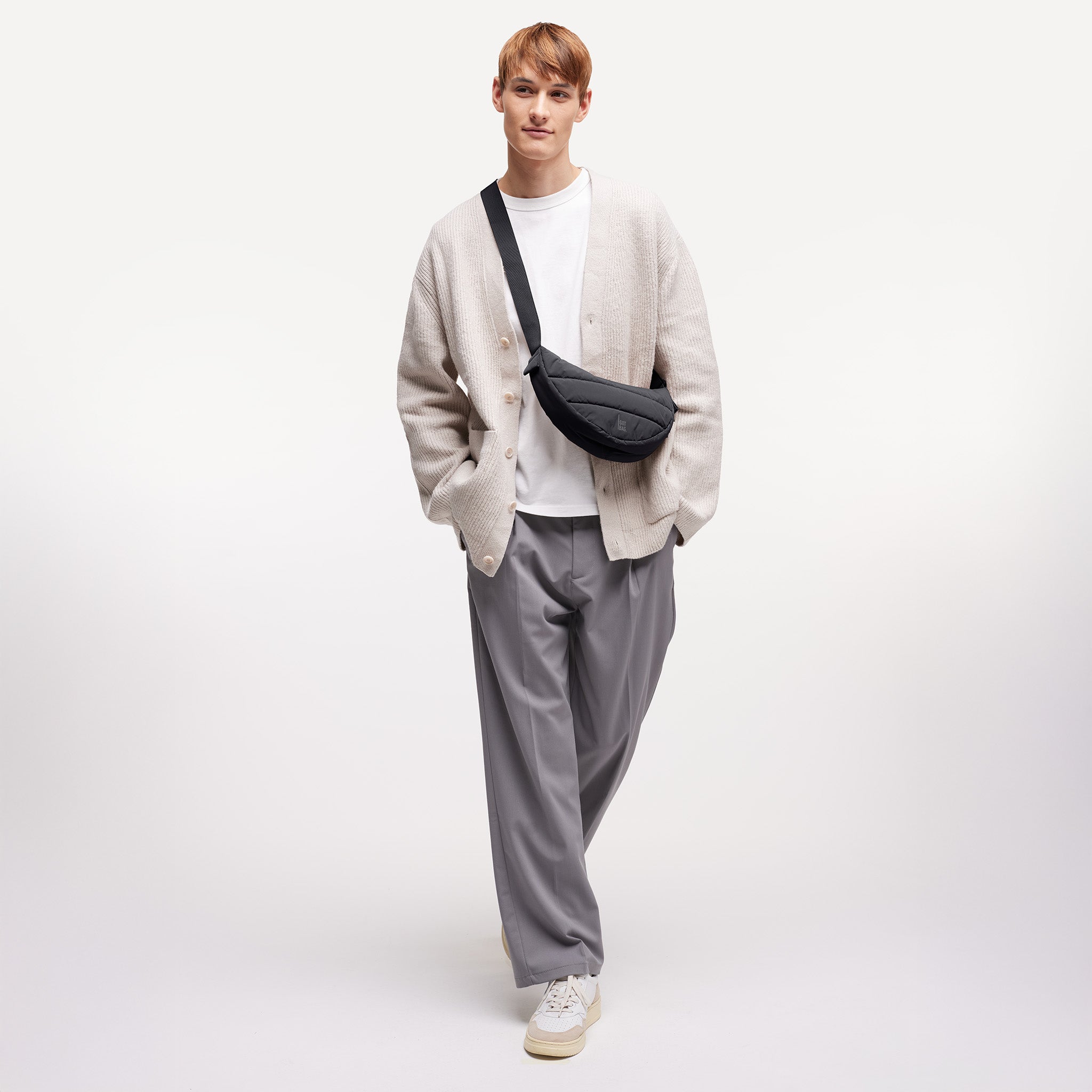 PUFFER MOON BAG SMALL Tasche in black (Schwarz) von einem Mann crossbody getragen.