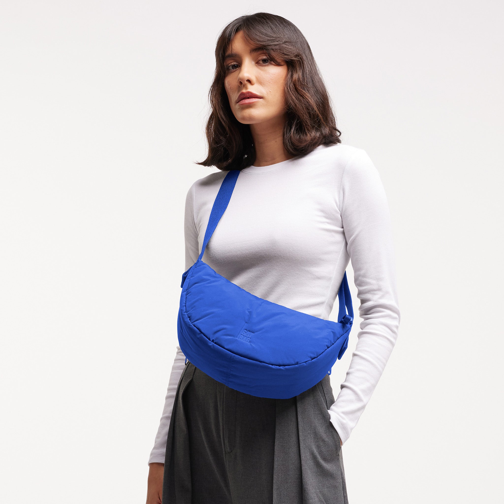 CLOUD MOON BAG SMALL Tasche in cobalt (leuchtendes Kobaltblau) von einer Frau crossbody getragen.