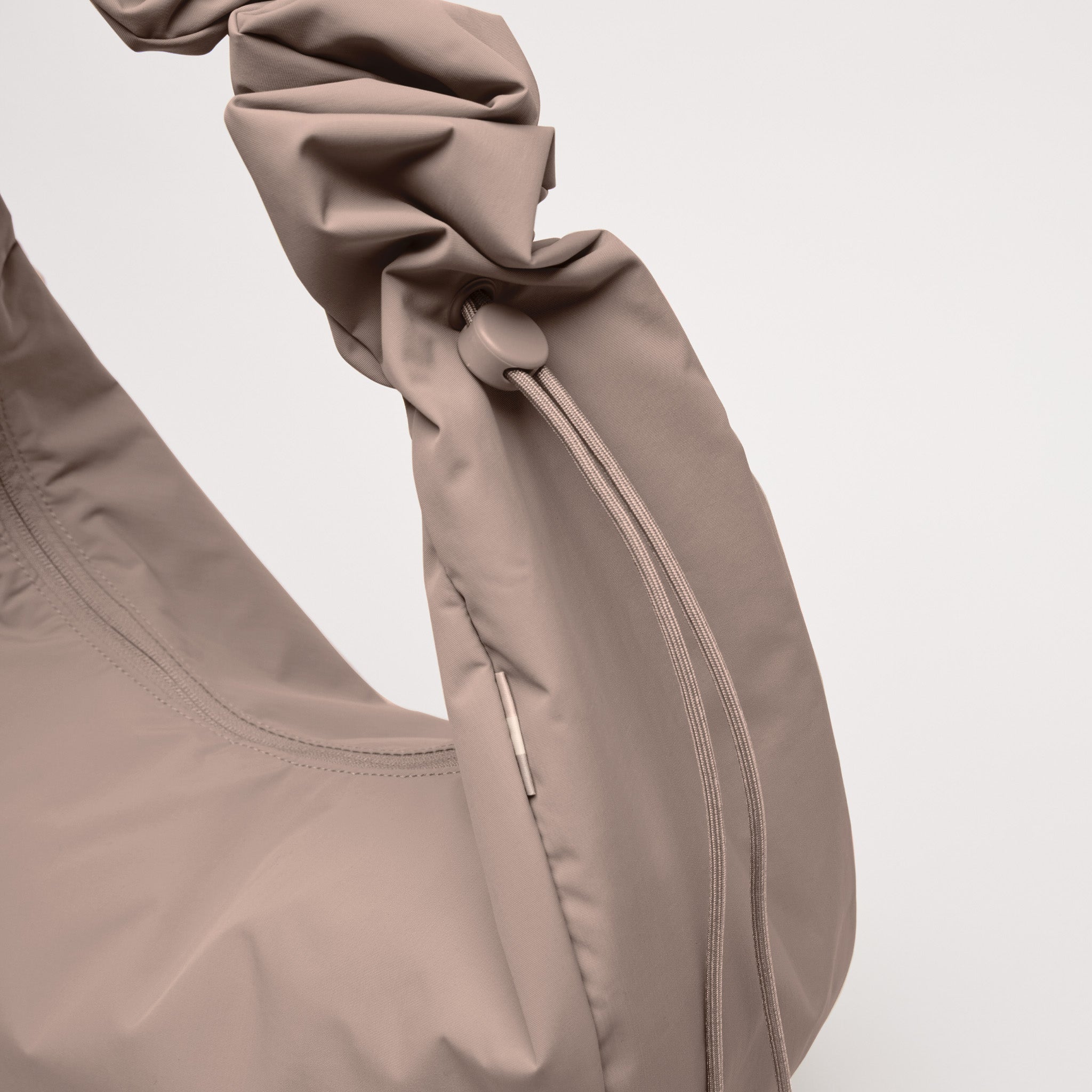 MOON BAG RUFFLE Tasche in oyster (klassisches Taupe-Braun) als Detailaufnahme der gerafften Schulterpartie und des Zugverschlusses.