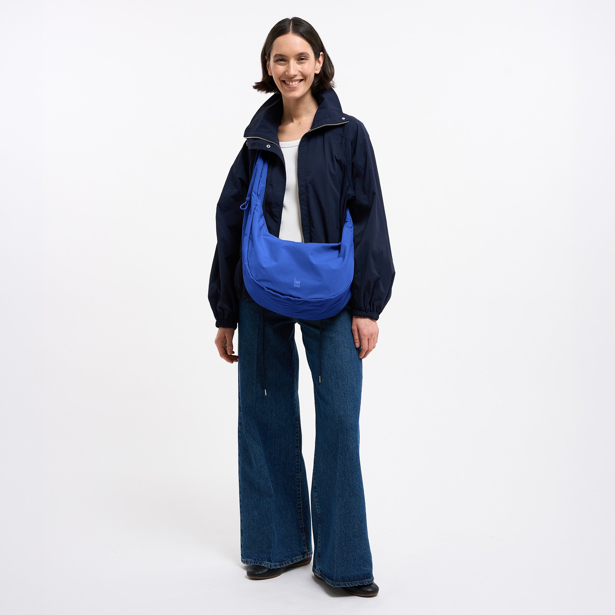 MOON BAG RUFFLE Tasche in cobalt (leuchtendes Kobaltblau) von einer Frau crossbody getragen.