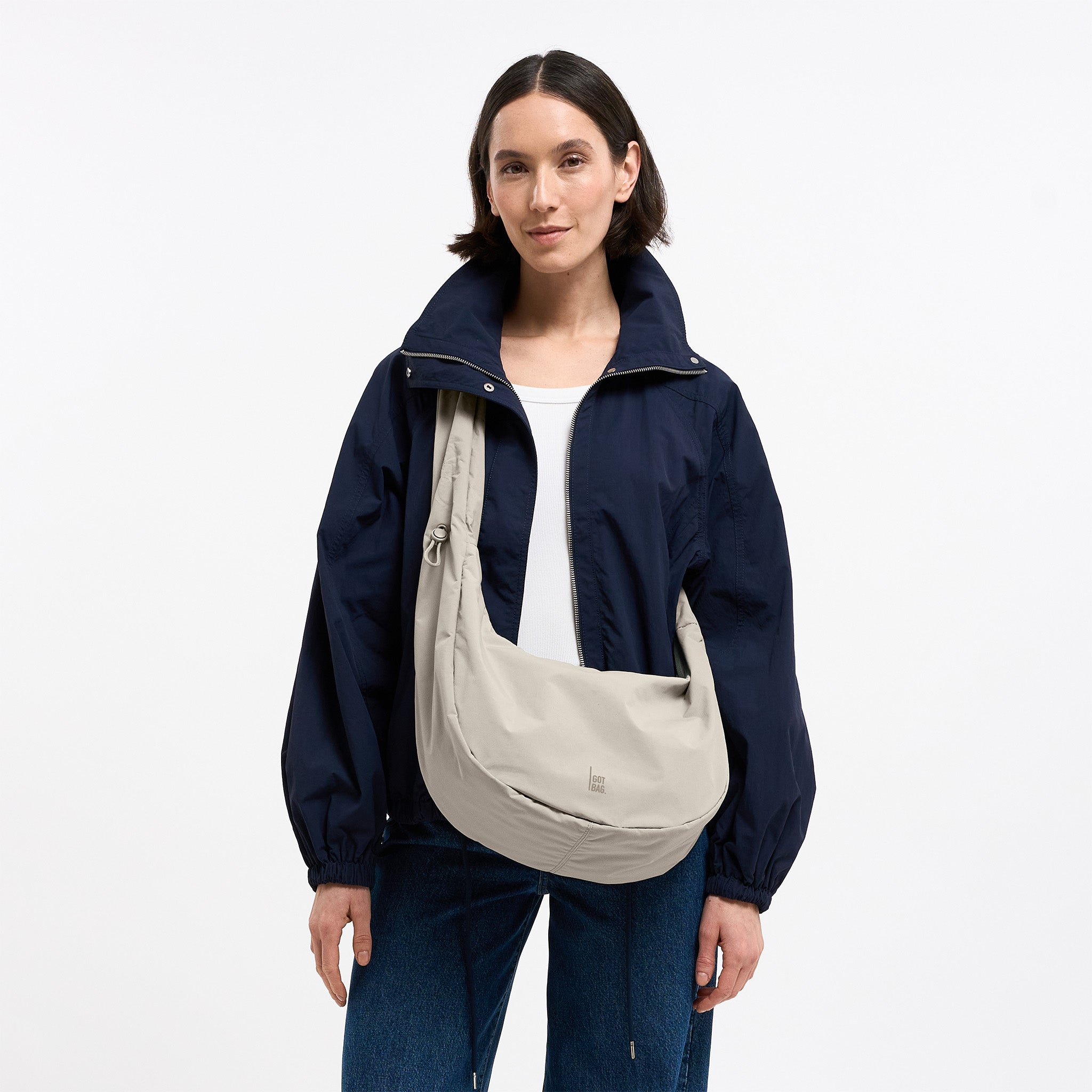 MOON BAG RUFFLE Tasche in soft shell (warmes Cremeweiß) von einer Frau crossbody getragen.