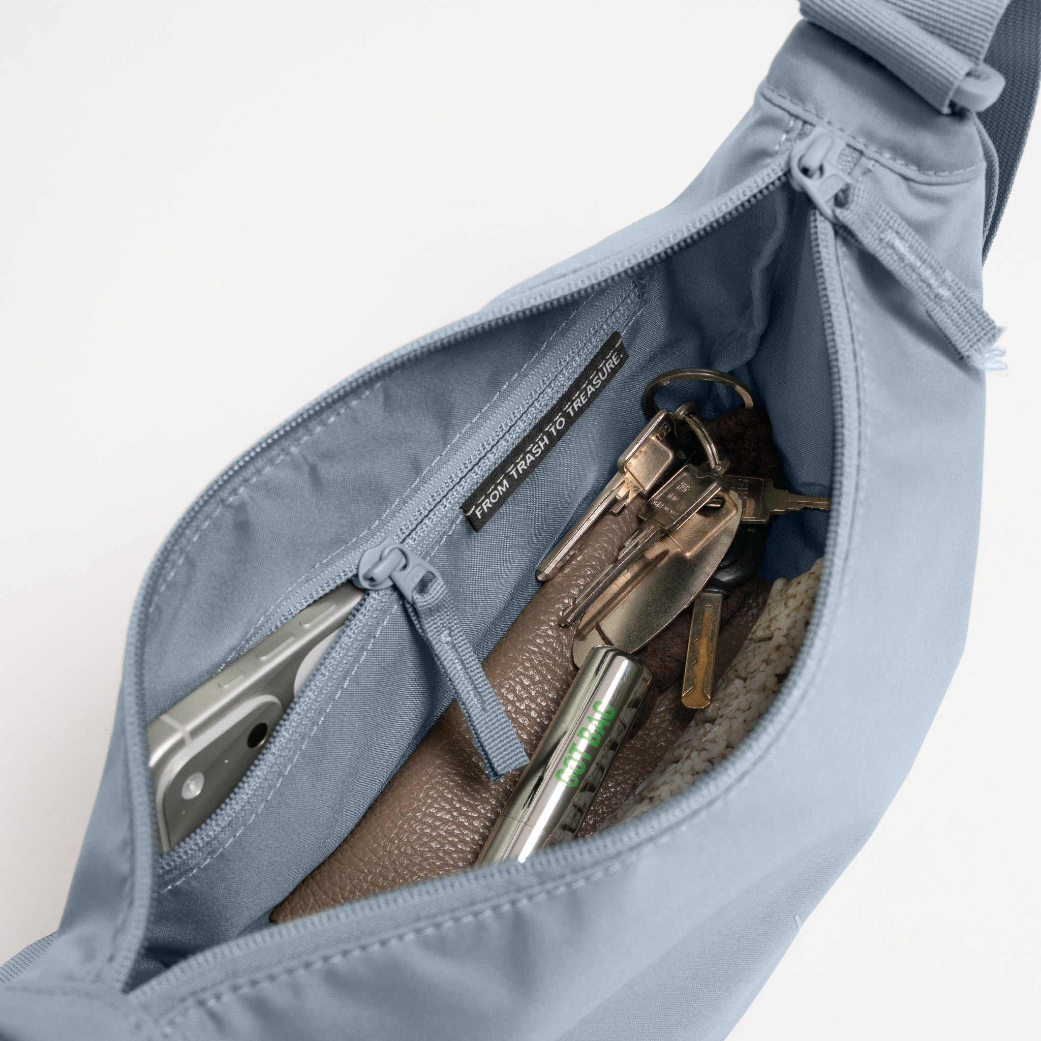 MOON BAG SMALL Tasche in marlin (grau-blau), Innenansicht mit Handy, Schlüsselbund, Label FROM TRASH TO TREASURE.