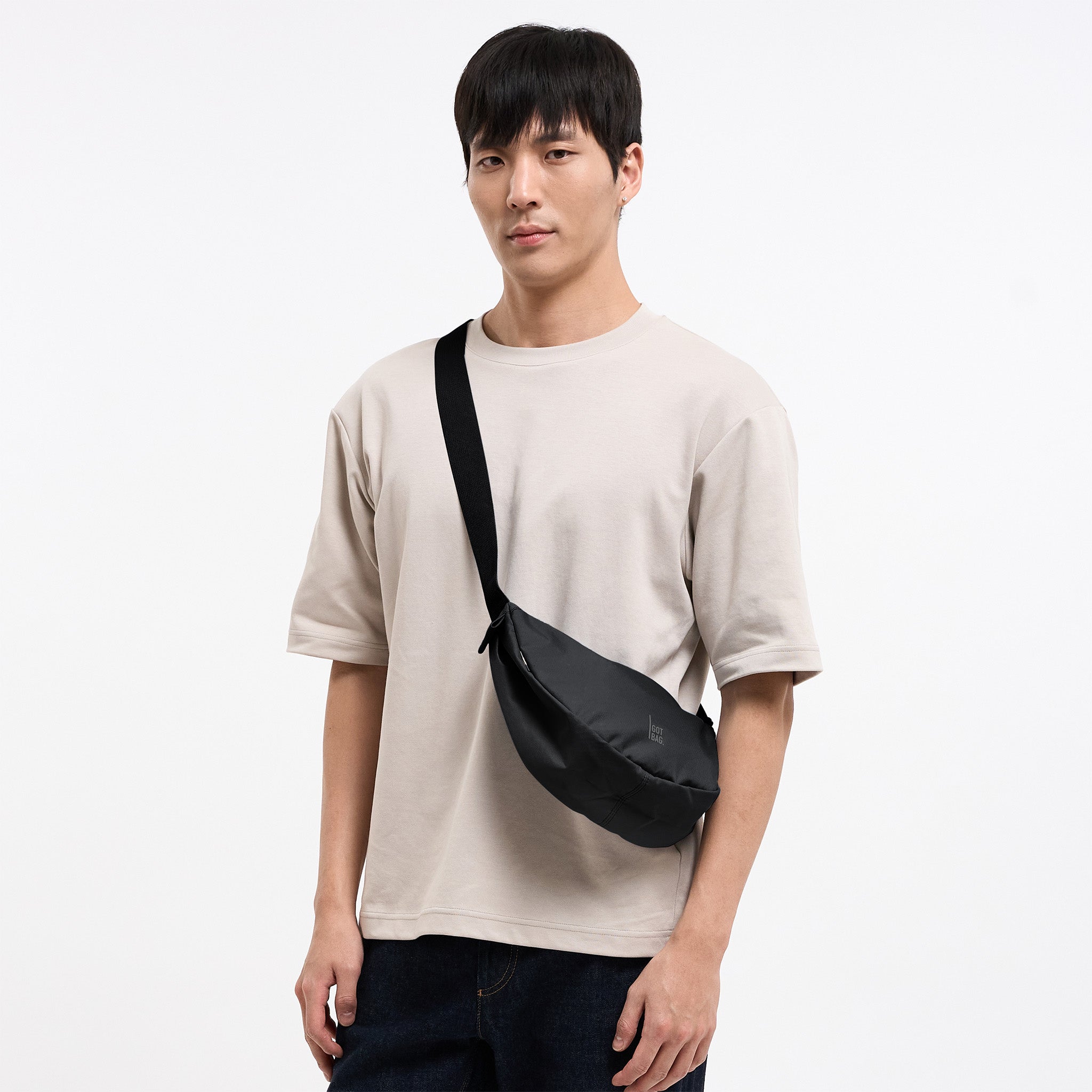 MOON BAG SMALL MONOCHROME Tasche in black (Schwarz) von einem Mann crossbody getragen.
