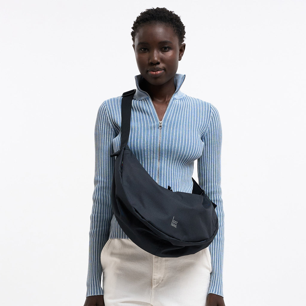 MOON BAG LARGE Tasche in black (Schwarz) von einer Frau crossbody getragen.