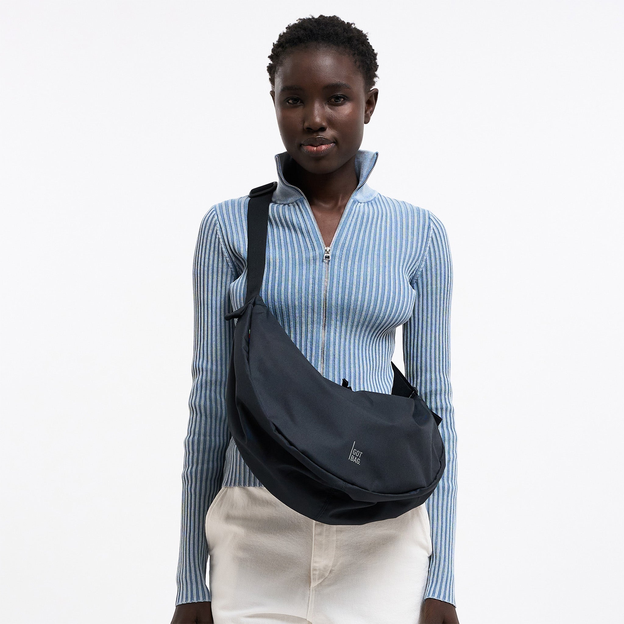 MOON BAG LARGE Tasche in black (Schwarz) von einer Frau crossbody getragen.