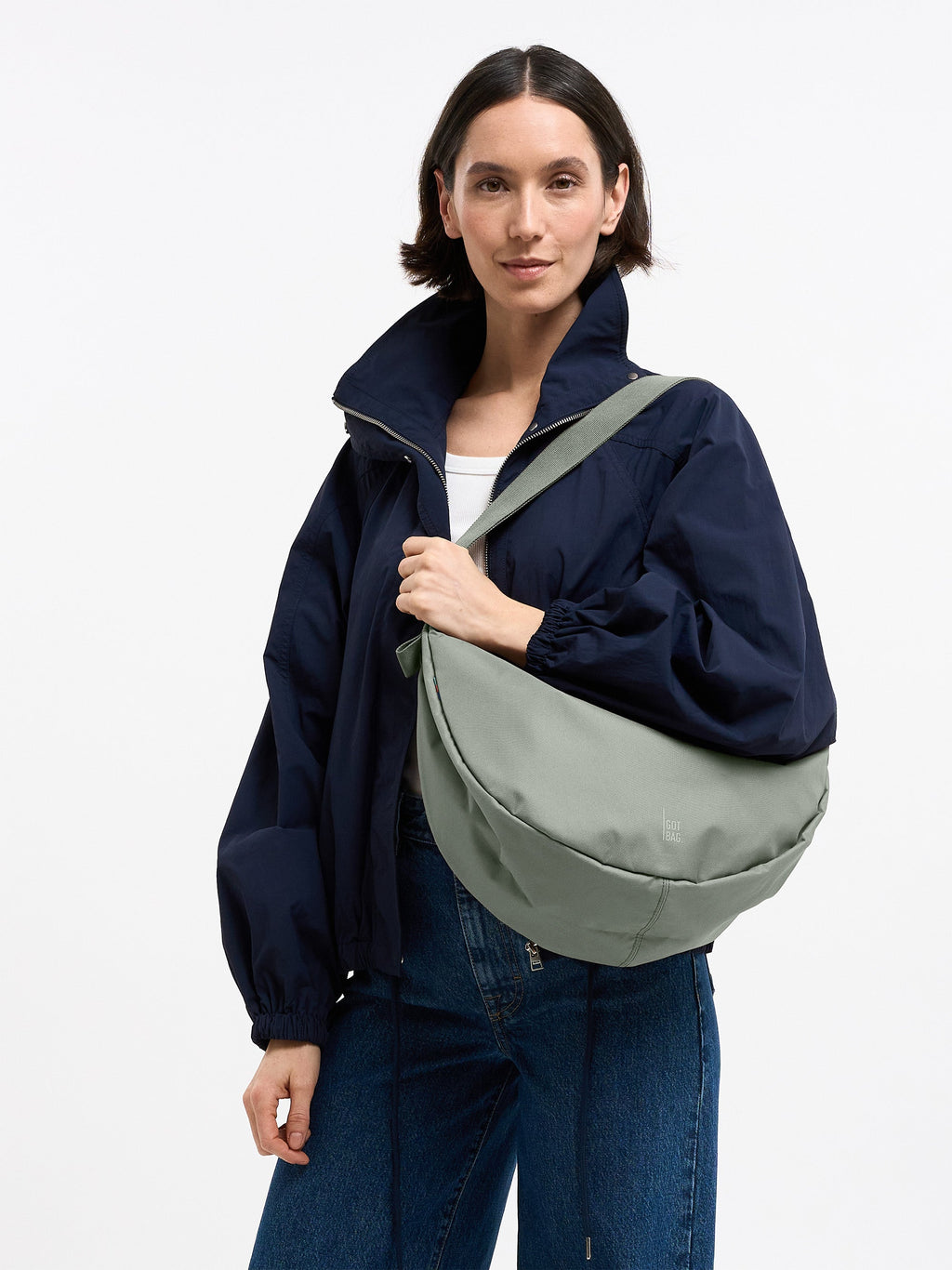 MOON BAG LARGE Tasche in bass (Salbeigrün) von einer Frau crossbody getragen.