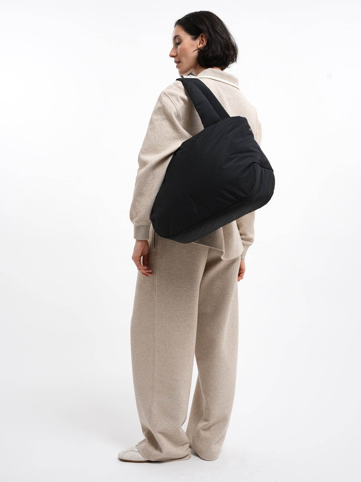 CLOUD HORIZON TOTE BAG Tasche in black (Schwarz) von einer Frau über der Schulter getragen.