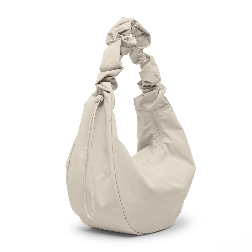 MOON BAG RUFFLE Tasche in soft shell (warmes Cremeweiß) als Studioaufnahme in diagonaler Ansicht.