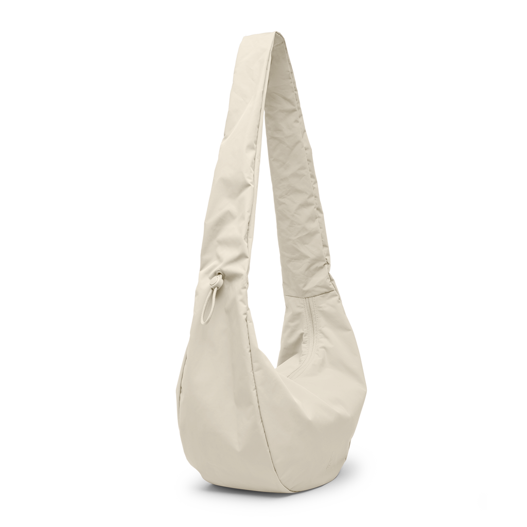 MOON BAG RUFFLE Tasche in soft shell (warmes Cremeweiß) als Studioaufnahme in diagonaler Ansicht.