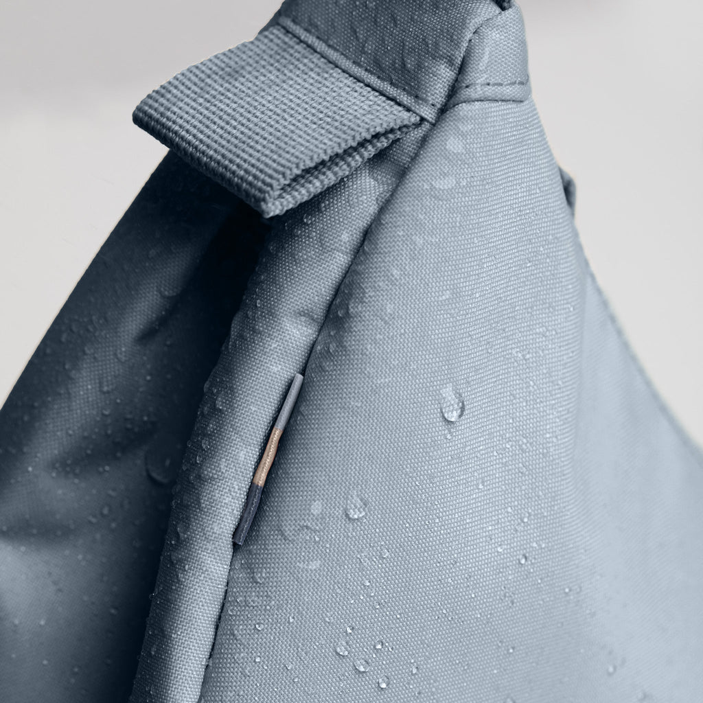 MOON BAG SMALL Tasche in marlin (grau-blau) als Detailaufnahme mit Wassertropfen.